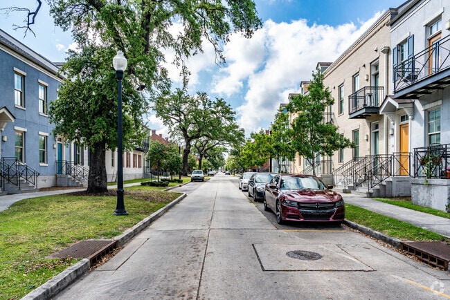 A street view of townhomes with shaded sidewalks in the Iberville neighborhood.