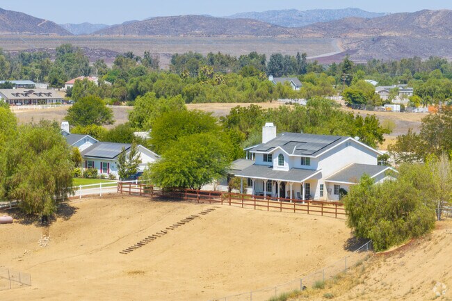 Homes in a dry, open landscape with rolling hills in the distance.