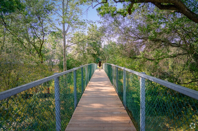Woman enjoys her walk over the peaceful sounds of Cirby Creek in Cirby Creekside.