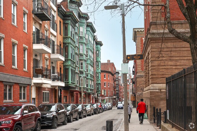 Wrought-iron fire escapes snake the exterior of brick buildings, in the North End.