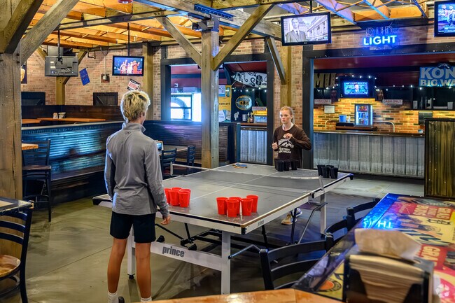 A couple of WMU students play beer pong at The Library Kitchen and Tavern in Knollwood.