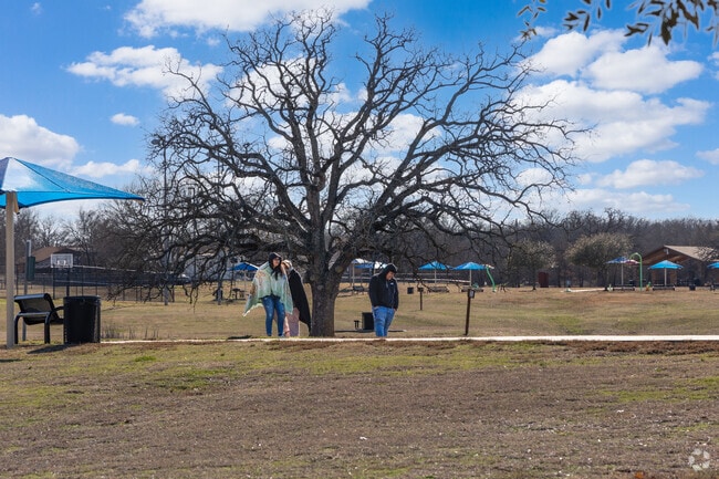 Residents walk the trail located at Joshua City Park.