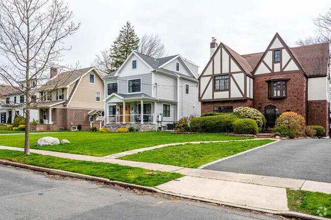 A healthy mix of Tudor and Colonial style homes on a tree lined street in Millburn, NJ.