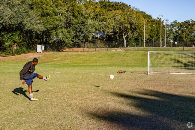 A man practices his goal kick on the soccer field at Palatkalaha Park in Clermont.