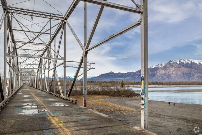Hikers cross the Old Knik River Bridge over the scenic Knik River.