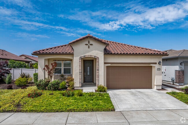 This Mediterranean influenced home has a tile roof and rock entryway in Sundance Lake.
