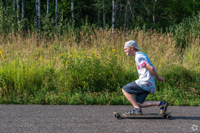 A man rides his skateboard down the pavement at Oneota Park by the Bayview Heights neighborhood.