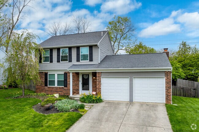 A traditional two-story home in Mill Run features beautiful landscaping.