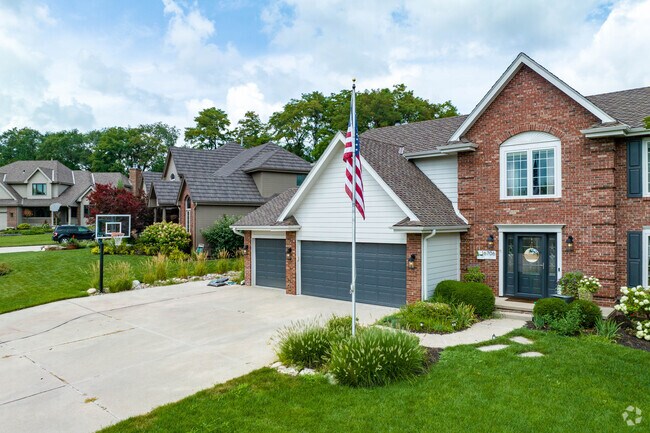 Two-story home with a three-car garage and an American flag in Armbrust Acres.