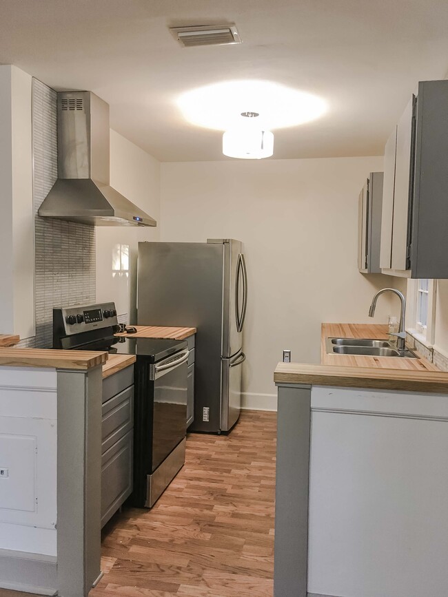Kitchen has new samsung appliances, marble tile, sink/faucet, and butcher block countertops.