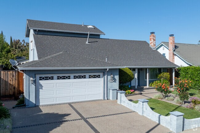 This Traditional-style home in Cahalan features a pitched roof, bay window, and blooming rose garden.
