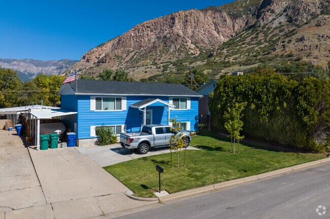 This bright blue home with white details stands out agains the mountains.