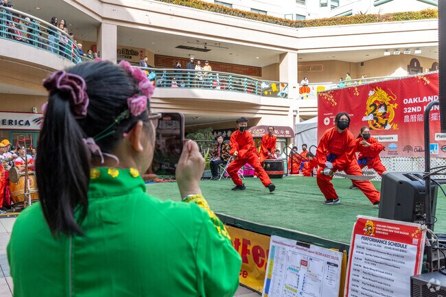 Performers dressed in red, bejeweled qipao dresses parade  at the Lunar New Year Bazaar.