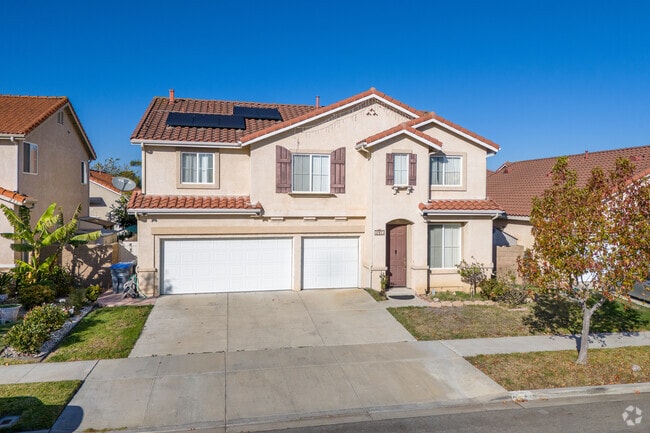 This larger 5-bedroom home with red-tiled roof and Spanish-infused exterior is located in Oxnard