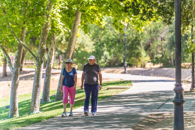 A couple walks along the Creek at on the Creekside Park trail.