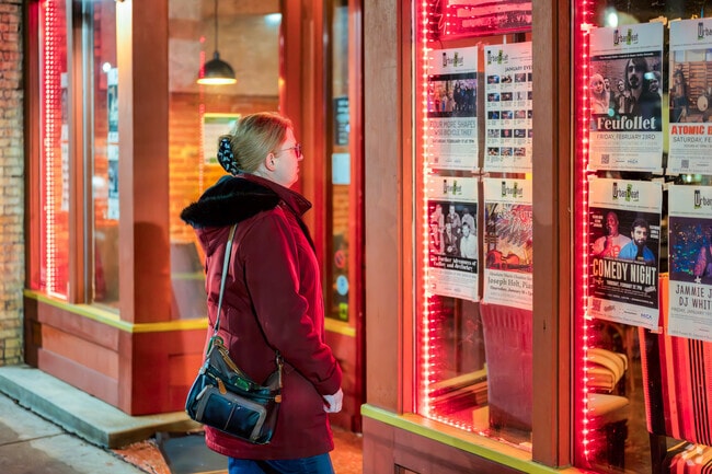 A woman reviews upcoming entertainment options in the Old Town neighborhood, near Old Forest.