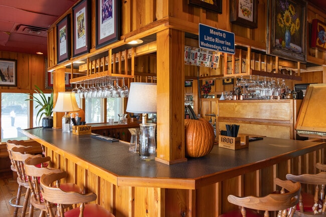 The bar at Poor Boy's Riverside Inn offers classic cocktails and modern yet rustic atmosphere in Pilette.