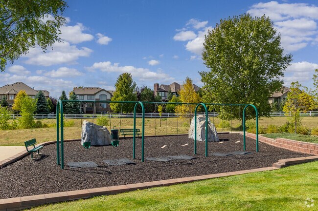 Huntington Trails HOA park includes a swing set and climbing boulder.