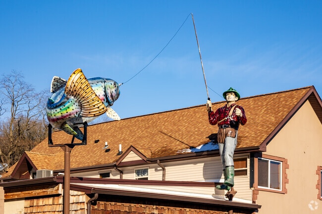 A large sculpture of a man fishing sitting on top of Mad Dan's Restuarant's in Twin Lakes.