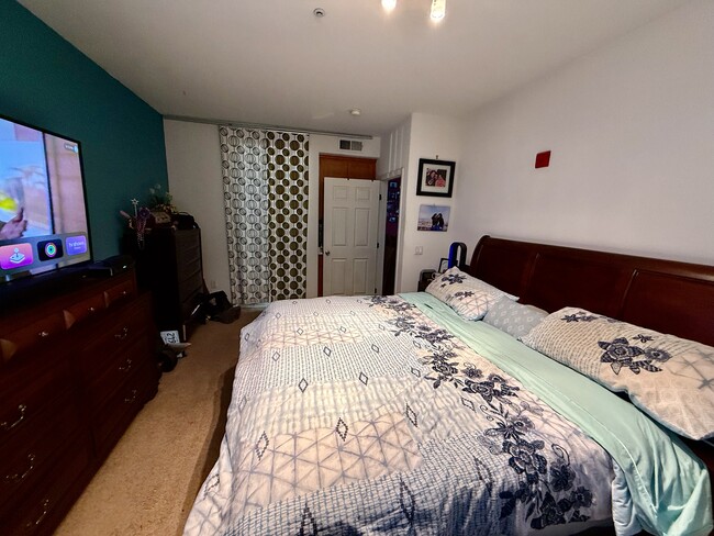 Master Bedroom with a King size bed, two side tables, dresser and a work table and chair