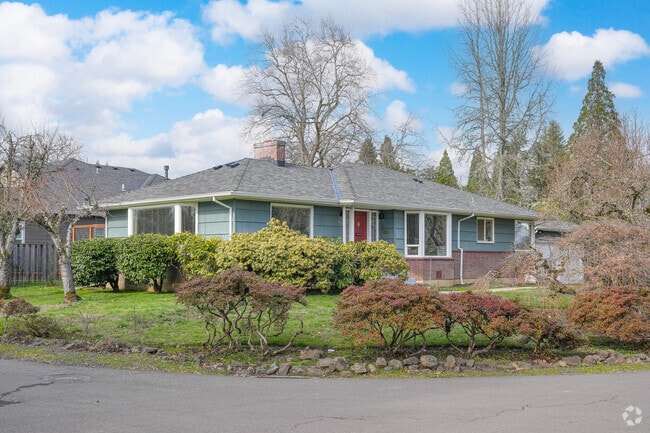 Ample tree cover and shrubs provides shade at this mid-century rancher in Northwest Hillsboro.