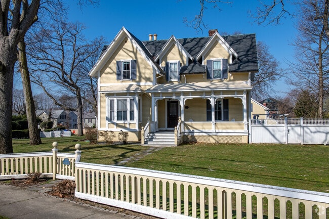 Gabled home with beautiful lawns and fences in Oak Hill's shades of yellow and white.