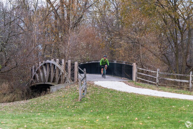A man rides his bike across the bridge in Martindale Park.