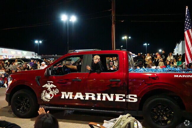 A child waves to crowds of over two thousand people at Festival of Lights.