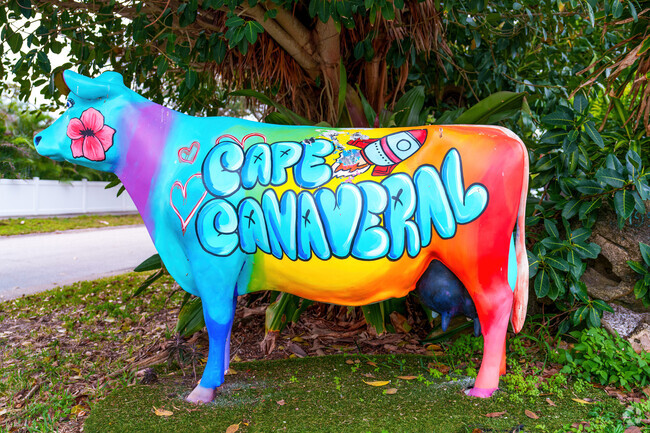 A vibrant cow statue greets visitors at a residential street in Cape Canaveral