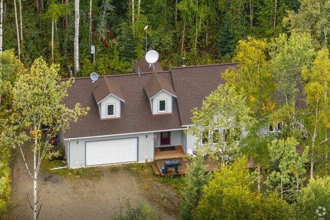 A traditional home with dormer windows is found in a heavily wooded area of Goldstream.