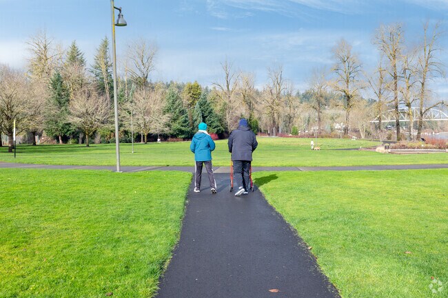 A couple enjoys a peaceful stroll through Foothills Park’s tree-lined paths.
