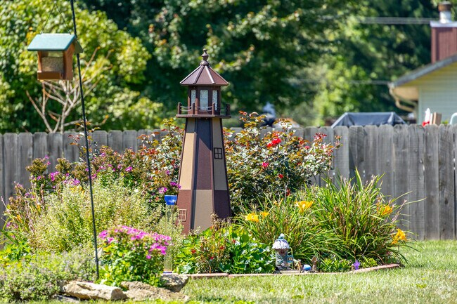 Monroe Park West residents decorate their lawns with fun lighthouse decor amongst flowers.