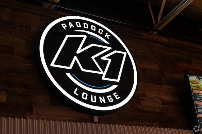 A bright sign made with light marks the K1 Paddock Lounge where guests can relax and get a bite