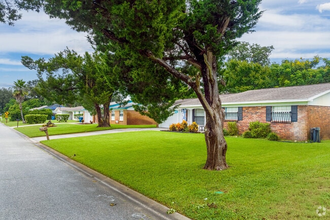 A row of ranch-style homes in Neighborhood K displays brick facades and well-maintained lawns.