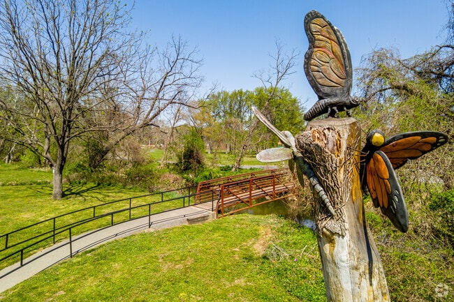 Visitors discover unique tree carvings with dragonflies and butterflies at Lane Manor Park.