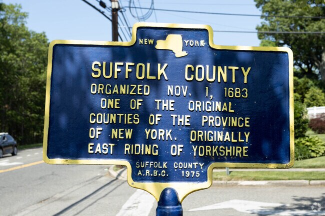 A historical sign posted in East Farmingdale, NY refers to the development of Suffolk County.