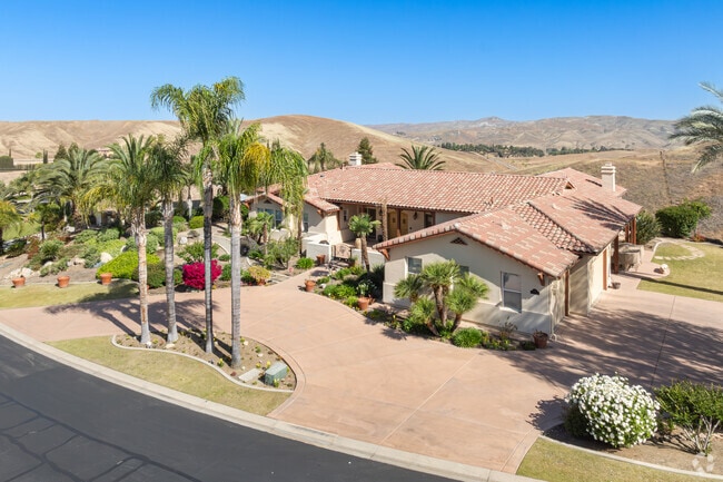 Large palm trees add character to a Spanish Revival home in Tuscany.