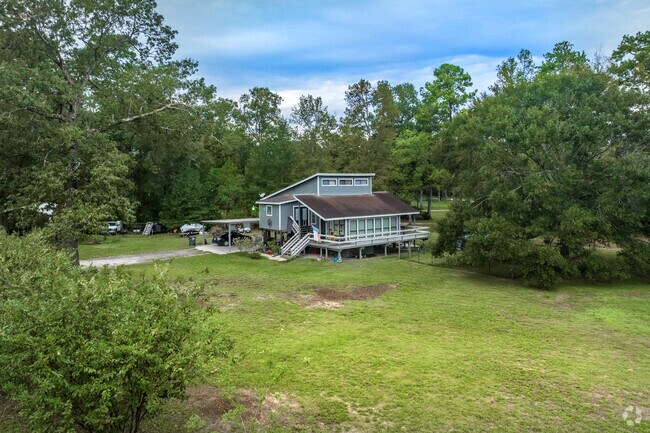 A two-story, wood-paneled home with large front and back yards in Woodbranch.