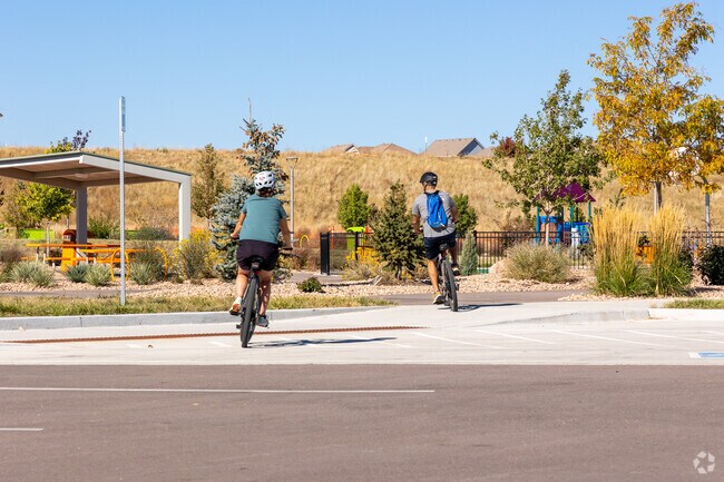 A couple rides their bikes into Cobblestone Ranch Park for a quick game of pickleball.