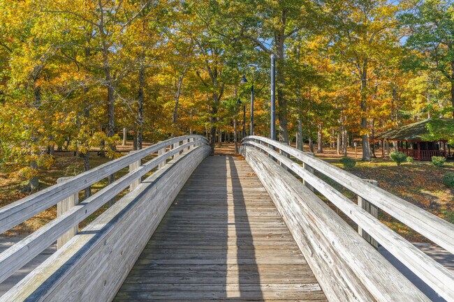 The bridge at Goddard Memorial State Park leads into a forest of vibrant fall leaves.