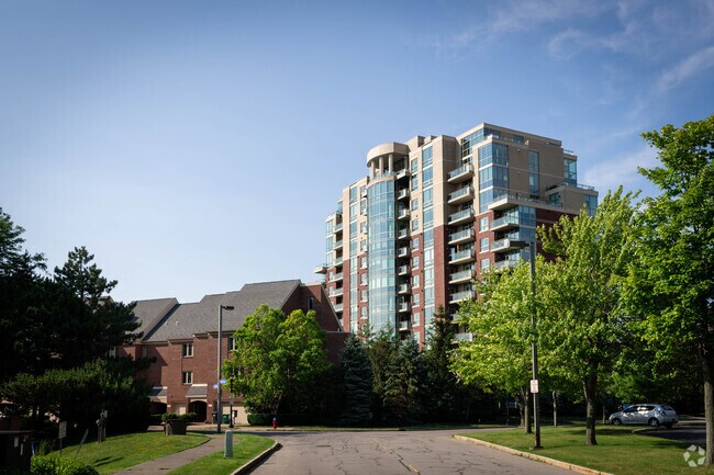 People in high-rise apartment buildings in Buffalo's Waterfront see the sun set over the water.