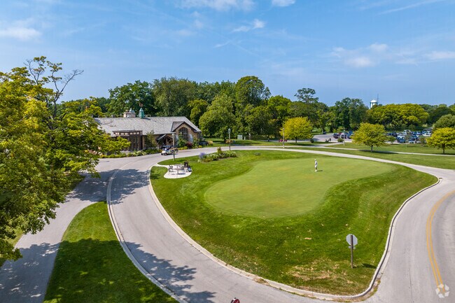 The putting green and clubhouse at Brown Deer golf course.