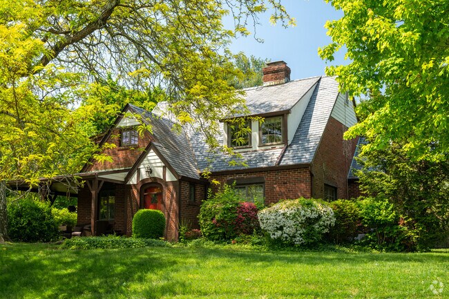 This shaded brick tudor home offers added privacy at a busy intersection.