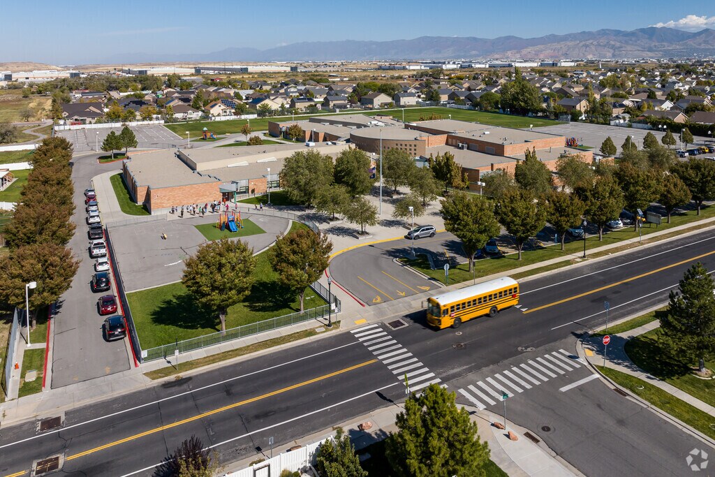 A yellow school bus passes in front of Gearld L Wright Elementary School.