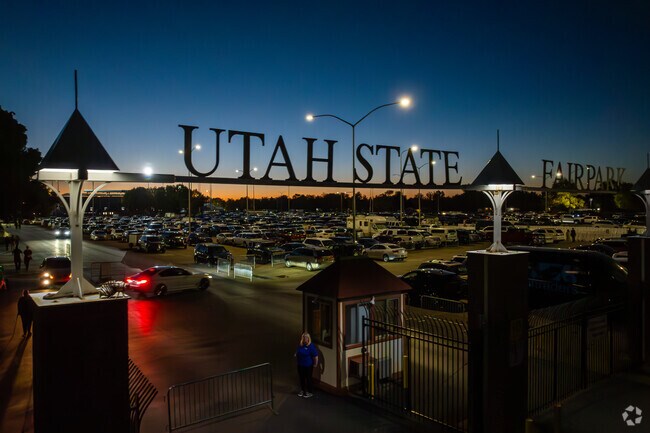 A gated entrance with metal letters spelling Utah State Fairpark stands out during blue hour.