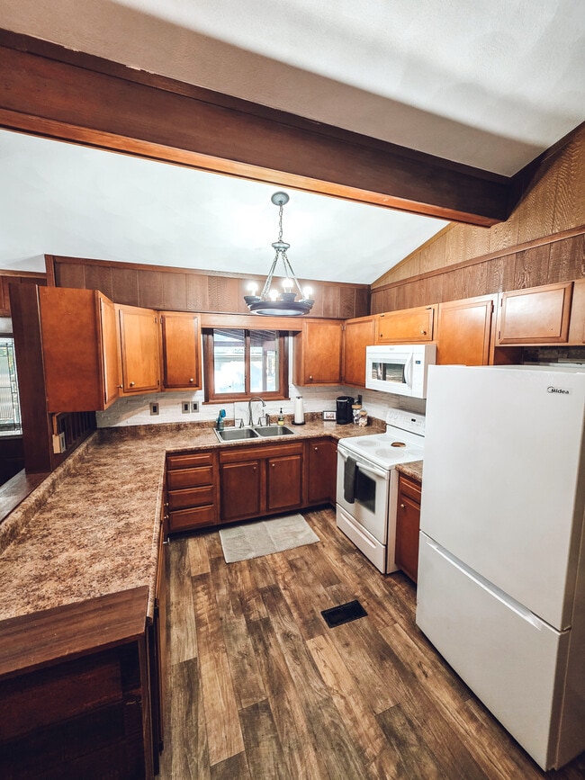 Kitchen with stove, microwave, refrigerator and includes cooking supplies