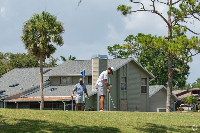 Two men enjoy a sunny round of golf on a fairway in El Conquistador.