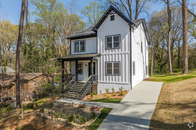Newly built traditional homes in Hammond Park sit hillside with towering shade trees.
