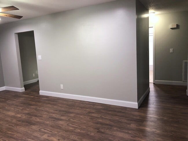Living room wall w/ the entrance to the kitchen and hall.