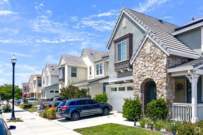 Townhomes with stone accents and porches welcome you home to Gilroy.